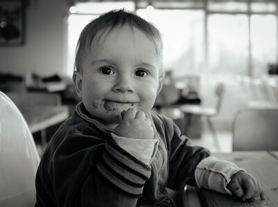 Baby in highchair feeding himself