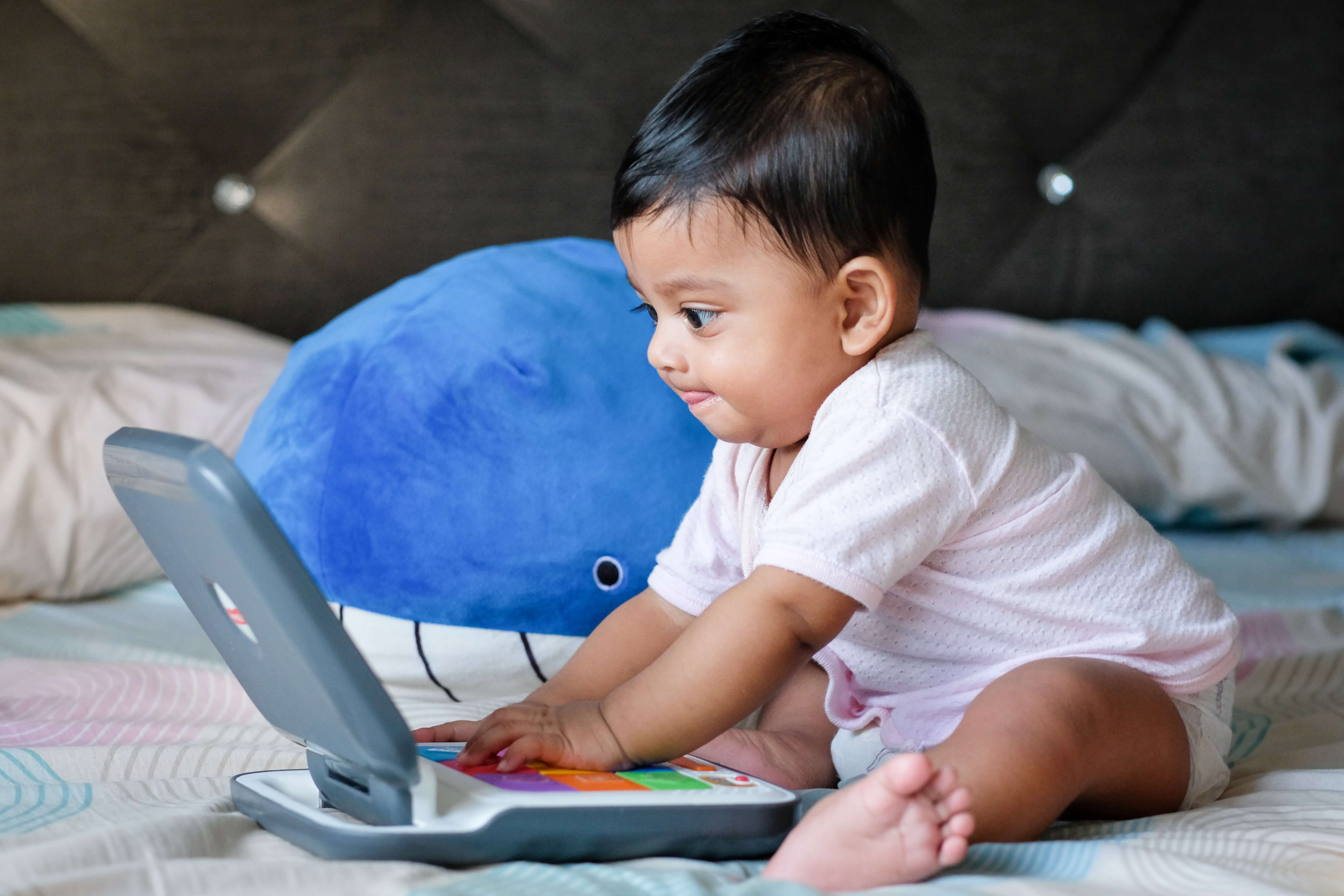 Infant playing on an electronic device