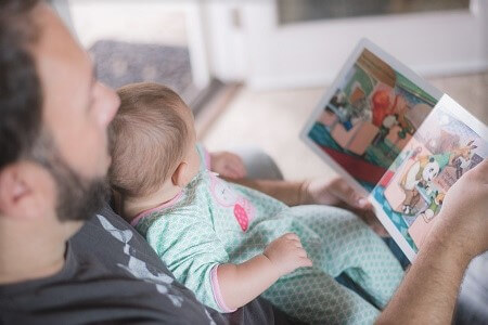 Father reading to baby on his lap Father reading to baby on his lap