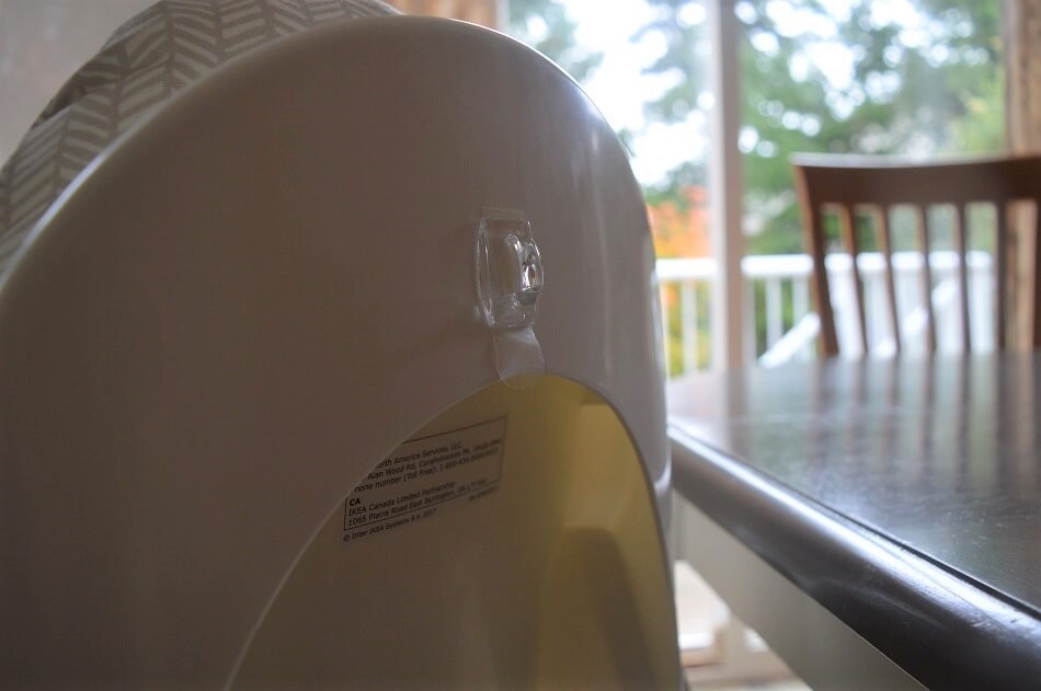 Clear Command hook on the back of a plastic baby feeding chair seat Clear Command hook on the back of a plastic baby feeding chair seat