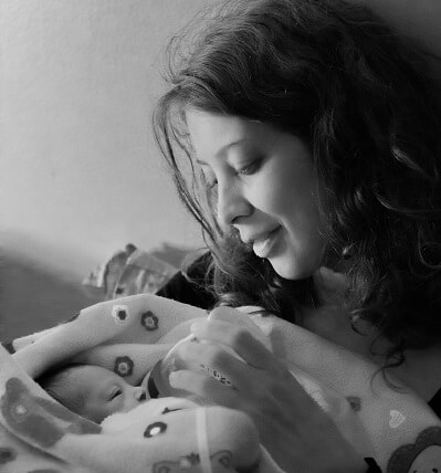 Mother holding and bottle-feeding newborn