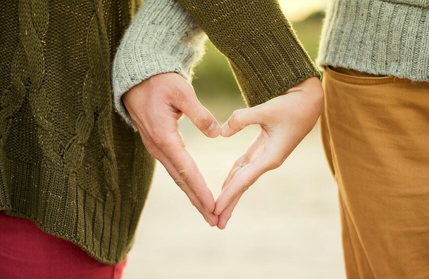 People parenting together holding hands in the shape of a heart People parenting together holding hands in the shape of a heart
